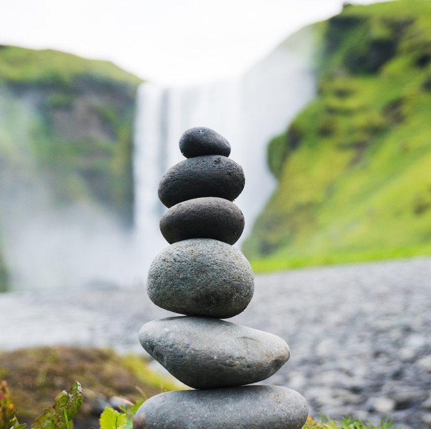 Balanced stones in front of a waterfall