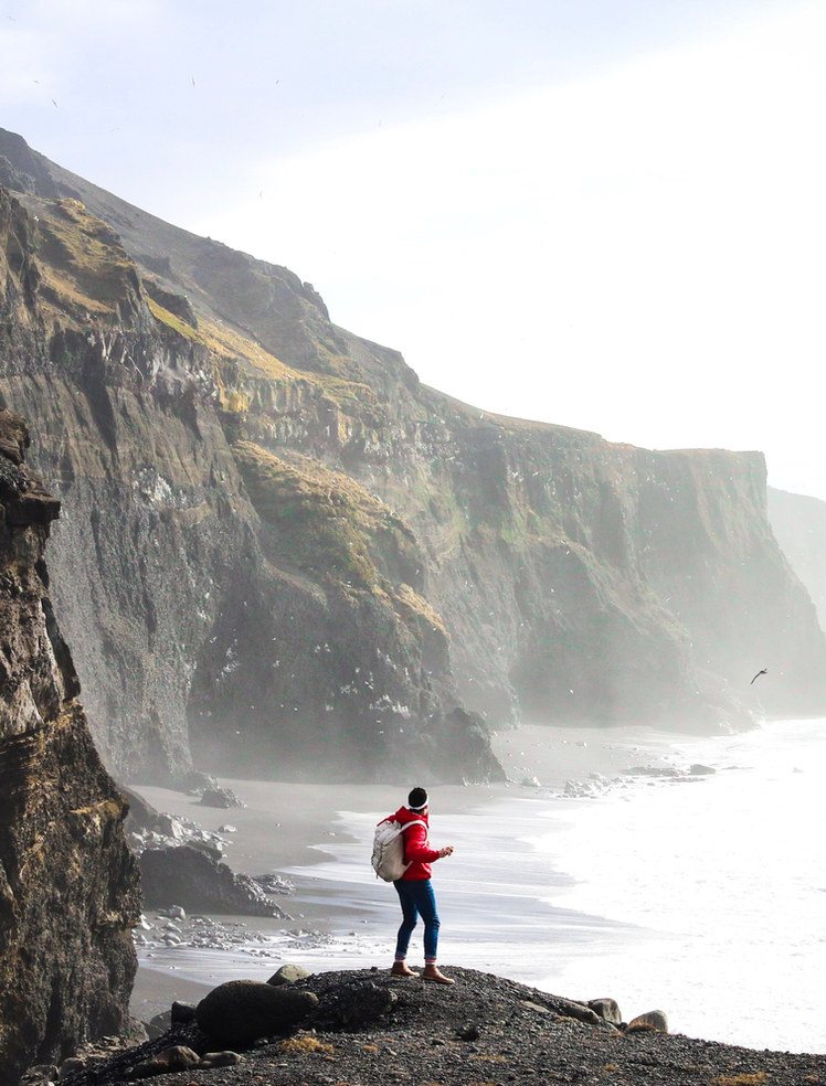 A walker standing on a cliff above the sea