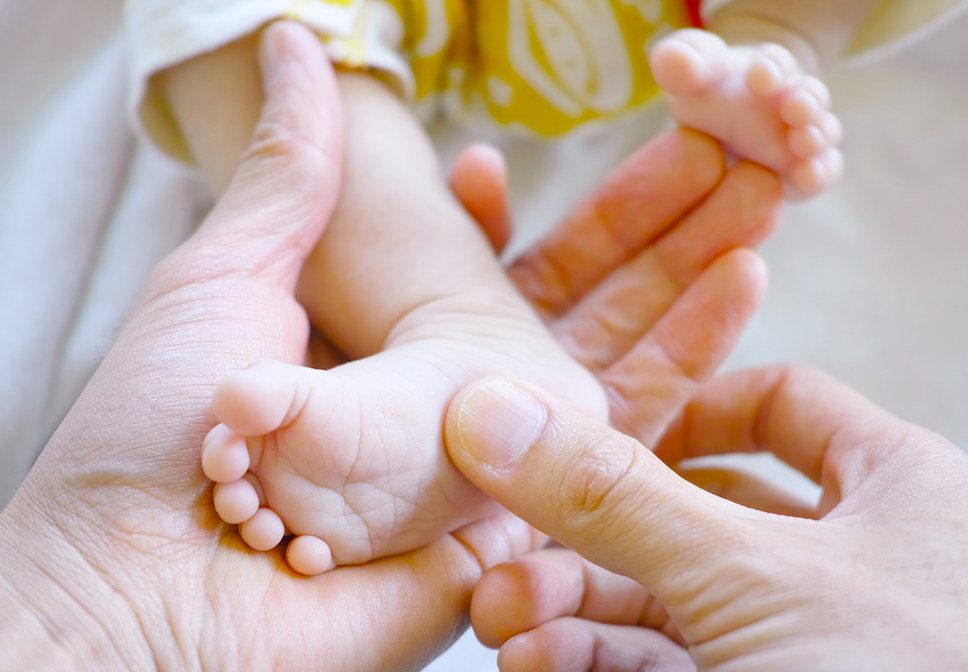 A newborn baby's feet being held